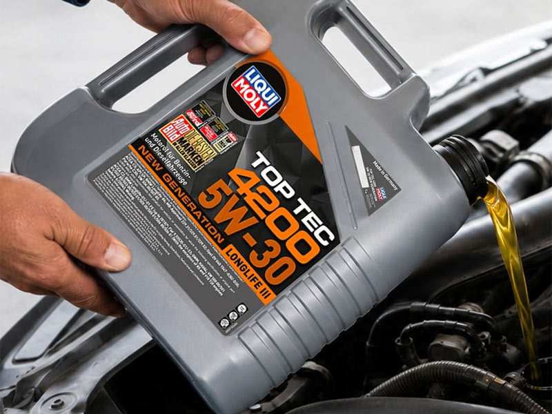 Persona realizando el cambio de aceite de coche vertiendo Liqui Moly Top Tec 4200 5W30 directamente en el motor